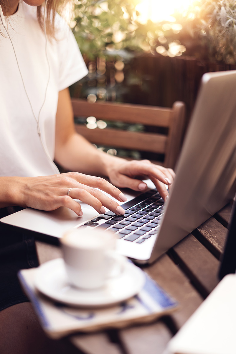 Young woman working with laptop on summer balcony